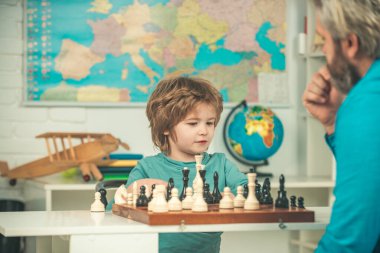 Konsantre çocuk satranç stratejisi geliştiriyor, masa oyunu oynuyor. Eğitici oyunlar. Çocuk evde satranç oynuyor..