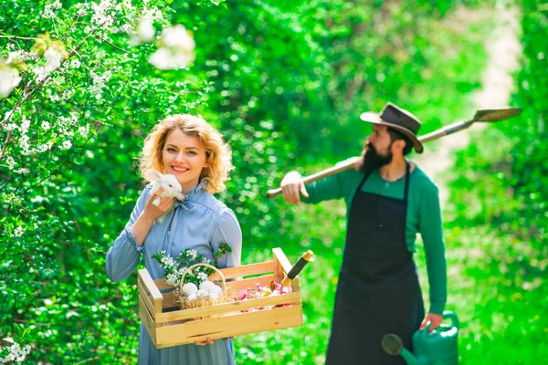Farming gardening and people concept. Couple of farmers seedling sprouts in the garden. Country life. — Stock Photo, Image
