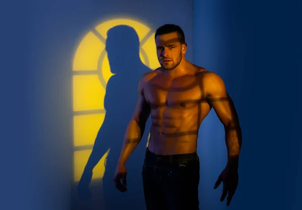 Homme nu avec un corps fort. Un torse. Portrait de l'homme torse nu musclé posant sur fond bleu néon . — Photo