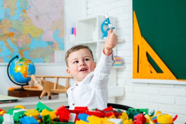 Okulda mutlu, gülümseyen bir çocuk. Sınıfın içinde bir çocuk var. Okula dönelim. Sınıftaki komik öğrenci. İlkokuldan küçük bir çocuk..