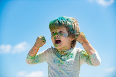 Komik çocuğun boyalı yüzü. Çocuk bayramı renk festivali. Küçük çocuk renklerle oynuyor. Çocuklar için konsept Hint festivali Holi.