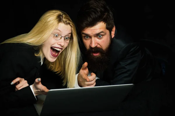 Excited couple rejoice in winning an internet lottery made bets on website. Happy couple celebrating victory in online competitions enjoying success. Portrait of a happy business couple looking at