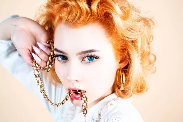 Mode modell hålla guld smycken i händerna. Kvinnans skönhet guld. Vackra rödhåriga flicka innehav smycken. — Stockfoto