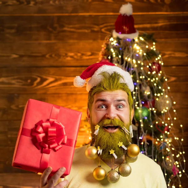 圣诞老人在老式木制背景上摆姿势.新年快乐。冬天的情绪满脸胡须的男人在室内圣诞树旁玩乐. — 图库照片