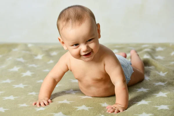 Aranyos kisbaba mászik. Családi reggel otthon. Textil- és ágynemű gyerekeknek. A kisbaba nevet. Gyönyörű mosolygós aranyos baba. Aranyos kisgyerek. Gyönyörű boldog gyerek.. — Stock Fotó