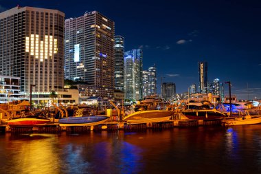 Miami Florida 'nın gece manzarası. Miami şehir panoraması, deniz üzerinde yansımalı şehir gökdelenleri..