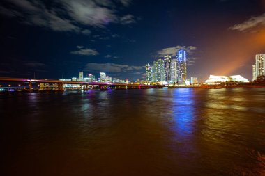 Günbatımından sonra Miami Skyline Panorama. Alacakaranlıkta şehir gökdelenleri ve deniz üzerinde yansıması olan bir köprü ile Miami şehri gökyüzü manzarası. Miami Florida.