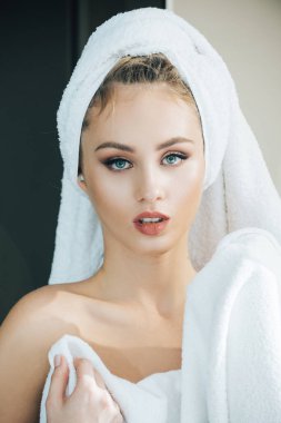 Havlu içindeki çıplak kız. Banyodan veya duştan sonra genç bir kadın. Kafasında beyaz havlu olan bir kız omuz omuza, çıplak makyaj, güzel bir fotoğraf..