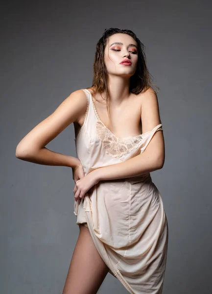 Высокая мода сексуальная женщина позирует. Молодая девушка возле серой стены. Модель моды, красивая молодая женщина. Модная девушка в современном платье . — стоковое фото