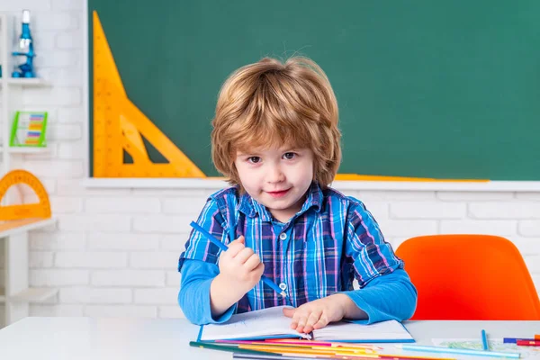 Leerling van de basisschool. Schoolkinderen tegen groen schoolbord. Kind maakt zich klaar voor school. — Stockfoto