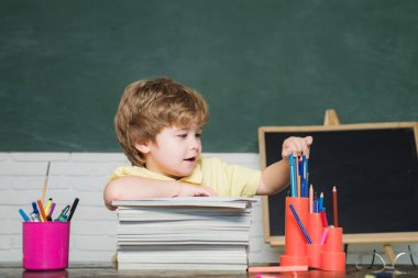 İlkokul ve eğitim konsepti. Eğitim. Çocuk okula hazırlanıyor. Tahtadaki neşeli gülümseyen çocuk. Çocuk okulu.