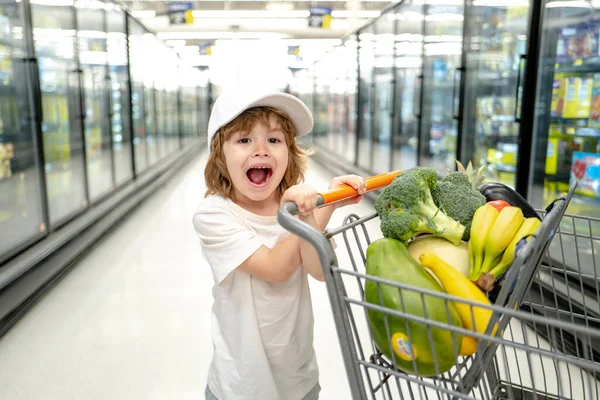 Mały chłopiec z torbą na zakupy w supermarkecie. Zakupy dzieci w supermarkecie. Supermarket, Zakupy z dzieckiem. — Zdjęcie stockowe