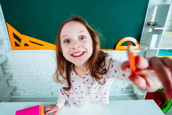 Menina engraçada em sala de aula perto de mesa de quadro-negro. O miúdo está a aprender nas aulas. Ensino pré-escolar . — Fotografia de Stock