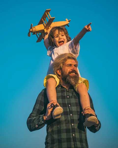 Πατέρας και γιος την ημέρα των πατέρων. Έννοια της φιλικής οικογένειας. Πατέρας και γιος παίζουν με το παιχνίδι αεροπλάνο στο ηλιοβασίλεμα το καλοκαίρι. — Φωτογραφία Αρχείου