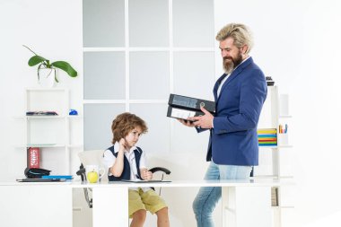 Ofisteki çocuk. İş adamı ofiste genç bir işçiyle konuşuyor. Ofisteki iş adamları ve danışmanlık. İdari görevli rapor veriyor. Eski ve yong iş konsepti. Patron ve çalışanı.