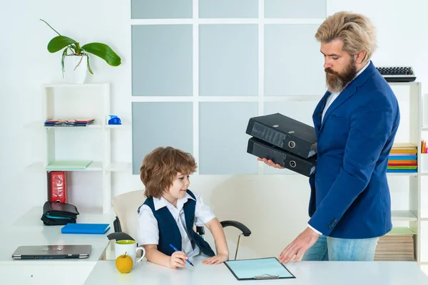 Business man talking with young worker in office. Business people at office and consulting. Managing employee on report. Kid in office. Old and yong business concept.