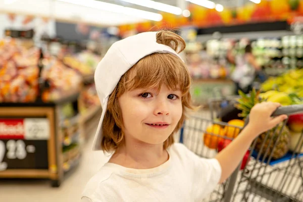 Un ragazzo al supermercato. Bambino con shopping bag in negozio . — Foto Stock