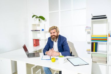 Dostane ve güler yüzlü patron. Ofisteki masasında oturan genç adamın portresi..