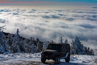 Karlı dağ yolunda off-road yolculuğu. 4x4 arabalı kış ravel konsepti. Jeep off-road maceraları.