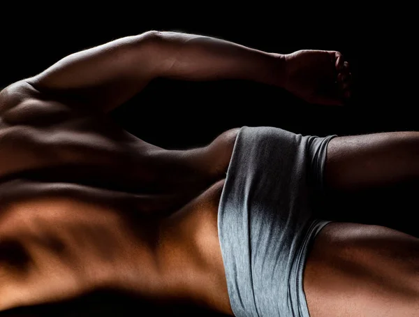 Sexig man med muskulös kropp och bara överkropp. Muskelrumpa. Bakåt bild av en muskulös man poserar på svart bakgrund. — Stockfoto