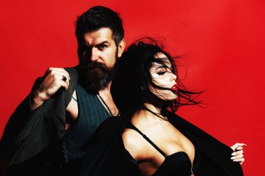 Seksi bir çift portresi. Tutku ve şehvetli dokunuş. Aşk konsepti. Sevgililer Günü. Şehvetli bir çift portresi. Siyah sutyenli esmer bir kız ve kırmızı arka planda sakallı bir adam izole edilmiş..