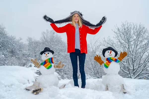 Boldog téli lány hóembert csinál. Karácsonyi izgatott emberek a szabadban. Nő Making hóember és a téli szórakozás. — Stock Fotó