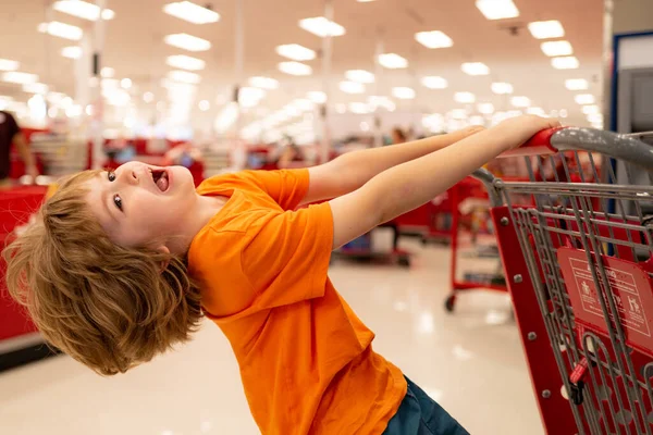 Vendita, consumismo e concetto di persone - bambini con cibo nel carrello della spesa al supermercato . — Foto Stock