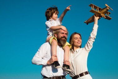 Aile babası ve oğlu seyahatin hayalini kurar. Yaz tatili ve tatil konsepti. Oğulları doğada ebeveynlerine sarılıyor. Çocuklu aile..