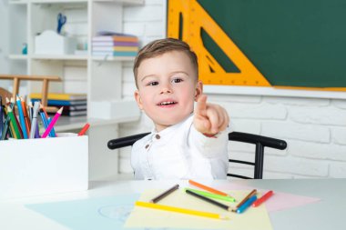 Öğrenci okulu. Bilim çocukları eğitim konsepti. Okula dönelim. İlkokuldan Küçük Çocuk. Küçük komik çocuk işaret ediyor.