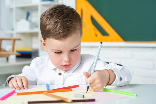 Söt liten förskolepojke i ett klassrum. Grundskola och utbildning. Processen för skolbarn. — Stockfoto