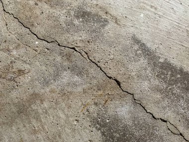 Beton zemindeki çatlağın yakın fotoğrafını çek. Yapısal onarım ve inşaat.