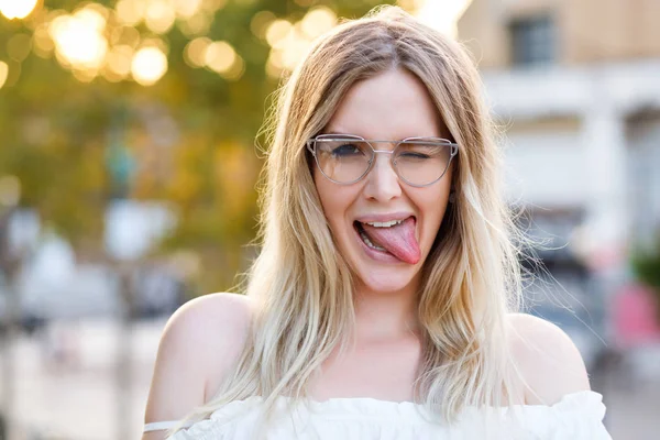 Junge Schöne Frau Posiert Auf Der Straße Und Zeigt Zunge — Stockfoto