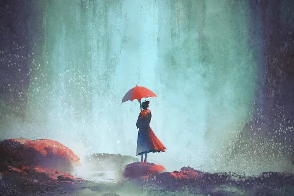 Kobieta z parasol stojący przed wodospad — Zdjęcie stockowe