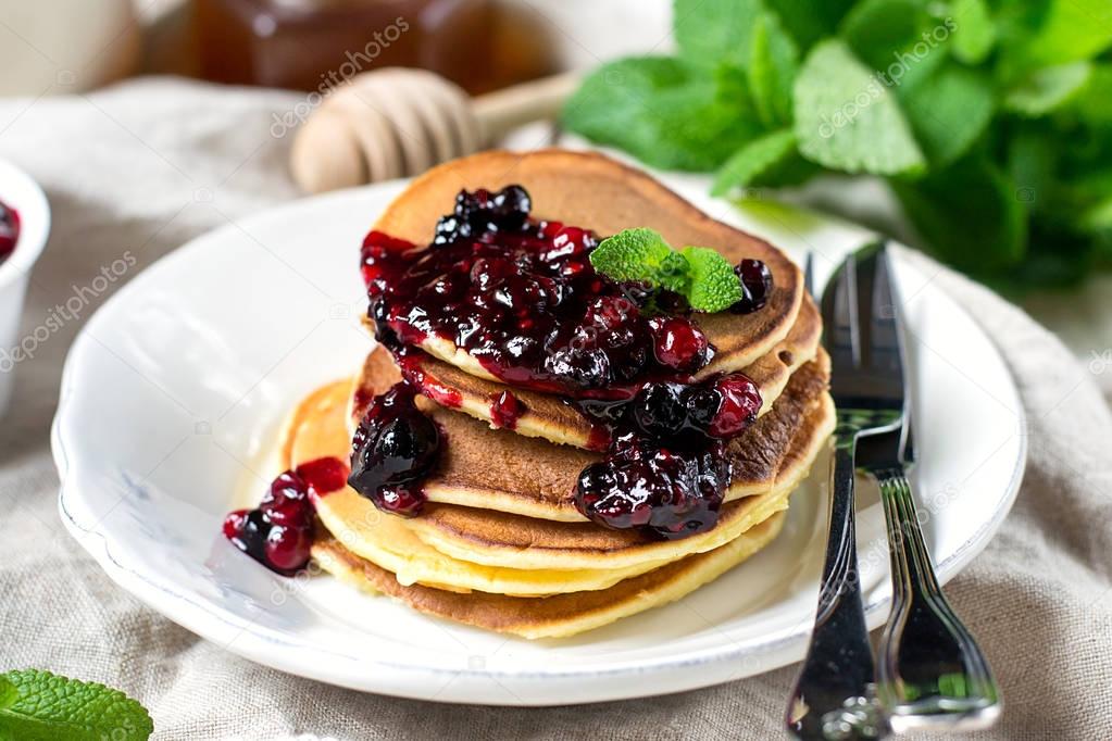 Homemade pancakes with berry sauce coulis and mint
