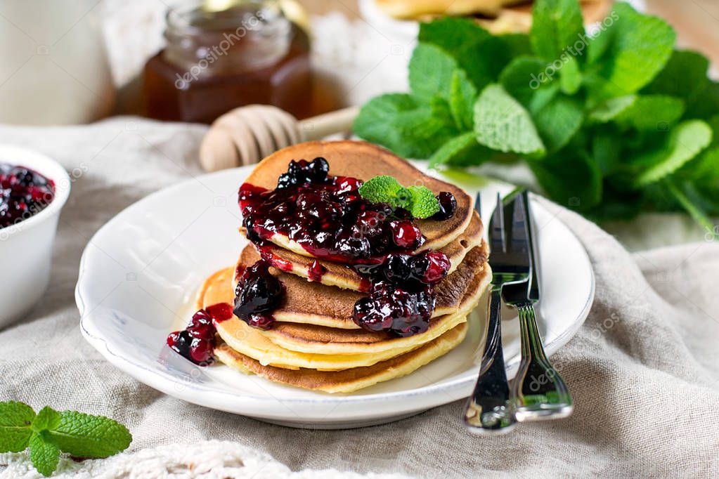 Homemade pancakes with berry sauce coulis and mint