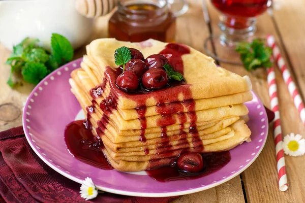 Stack of thin crepes with cherry topping — Stock Photo, Image