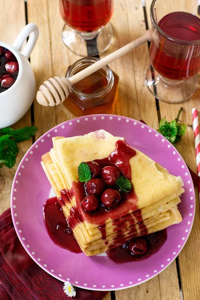 Stack of thin crepes with cherry topping — Stock Photo, Image