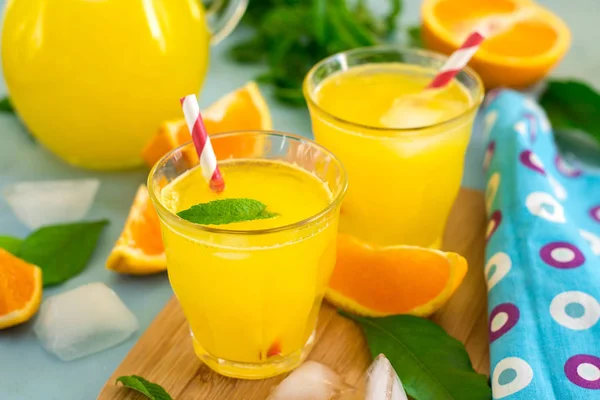 Słodki napój pomarańczowy z lodem i listkami mięty — Zdjęcie stockowe