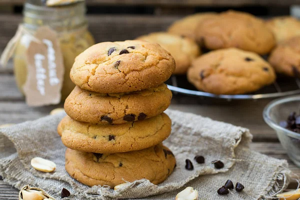 Mogyoróvaj cookie-kat, csokoládé chips, fából készült háttér — Stock Fotó