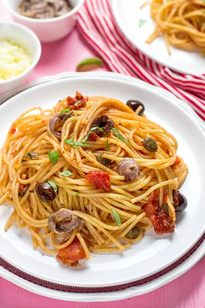 Těstoviny s rajčaty, olivami, kapary a ančovičky špagety alla — Stock fotografie