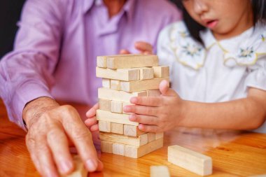 Bir dede torununa tahta kule oyunu öğretiyor..
