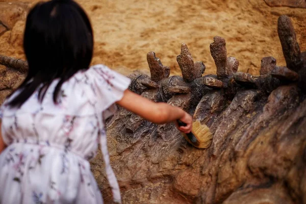 Ένα Κορίτσι Που Παίζει Ένα Αμμόλοφο Ένα Πρότυπο Απολίθωμα Δεινοσαύρου — Φωτογραφία Αρχείου
