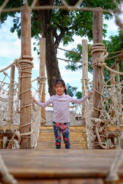 Tahta yapılı şirin bir Asyalı kız oyun bahçesinde oynuyor.. 