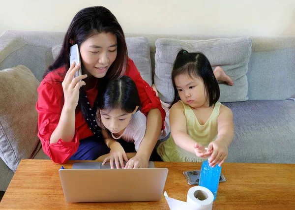 Covid-19 karantinası sırasında iş ve çocukları arasında hokkabazlık yaparak onu evden çalışmaya zorlayan çekici bir Asyalı kadın..