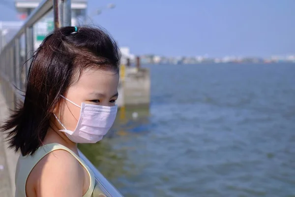 Una Linda Chica Asiática Con Una Máscara Quirúrgica Para Protegerla — Foto de Stock