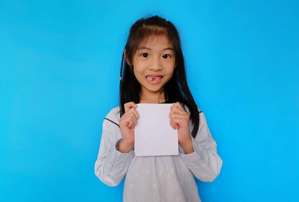 Açık mavi arka planda duran, elinde boş bir kağıt parçasıyla gülümseyen genç bir Asyalı kız..