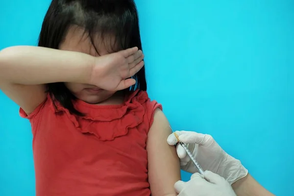 Koluna aşı yaptıran genç bir Asyalı kız klinikteki bir doktor tarafından iğne ve şırınga ile cesur olmaya çalışıyor ama korkuyor..