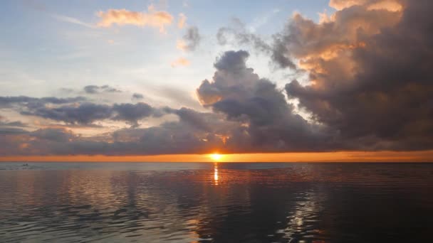 一个杜马格特的城市日出视频与火热的云在平静的海洋 在远处可以看到一艘当地的渔船 太阳刚刚越过地平线 — 图库视频影像