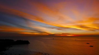 Bir koyu kırmızı günbatımı video güzel Camiguin Island kıyıları. Yerel balıkçı tekneleri siluetleri dolaşıyor görülebilir.