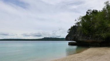 Beyaz kumlu plajları Siquijor Adası, ince dalgalar kıyıya ve volkanik kaya oluşumları isabet gösterilen bir klip çalıların kaplı.